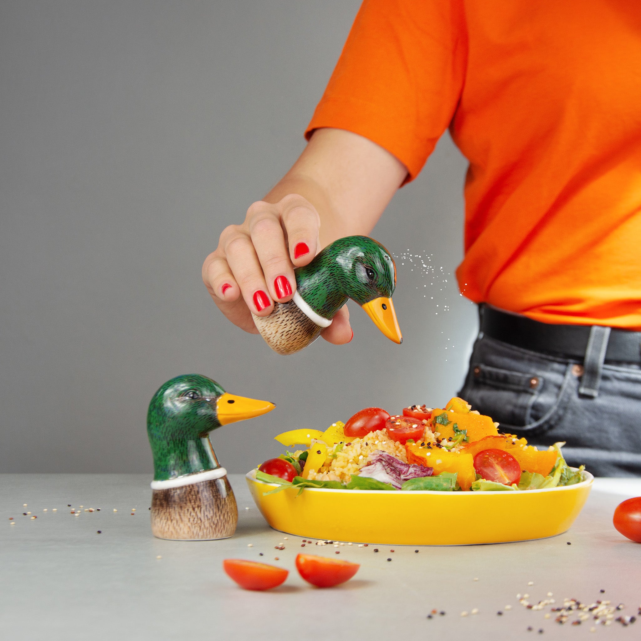 Eine Frau verwendet die Salz- und Pfefferstreuer Spicy Ducks