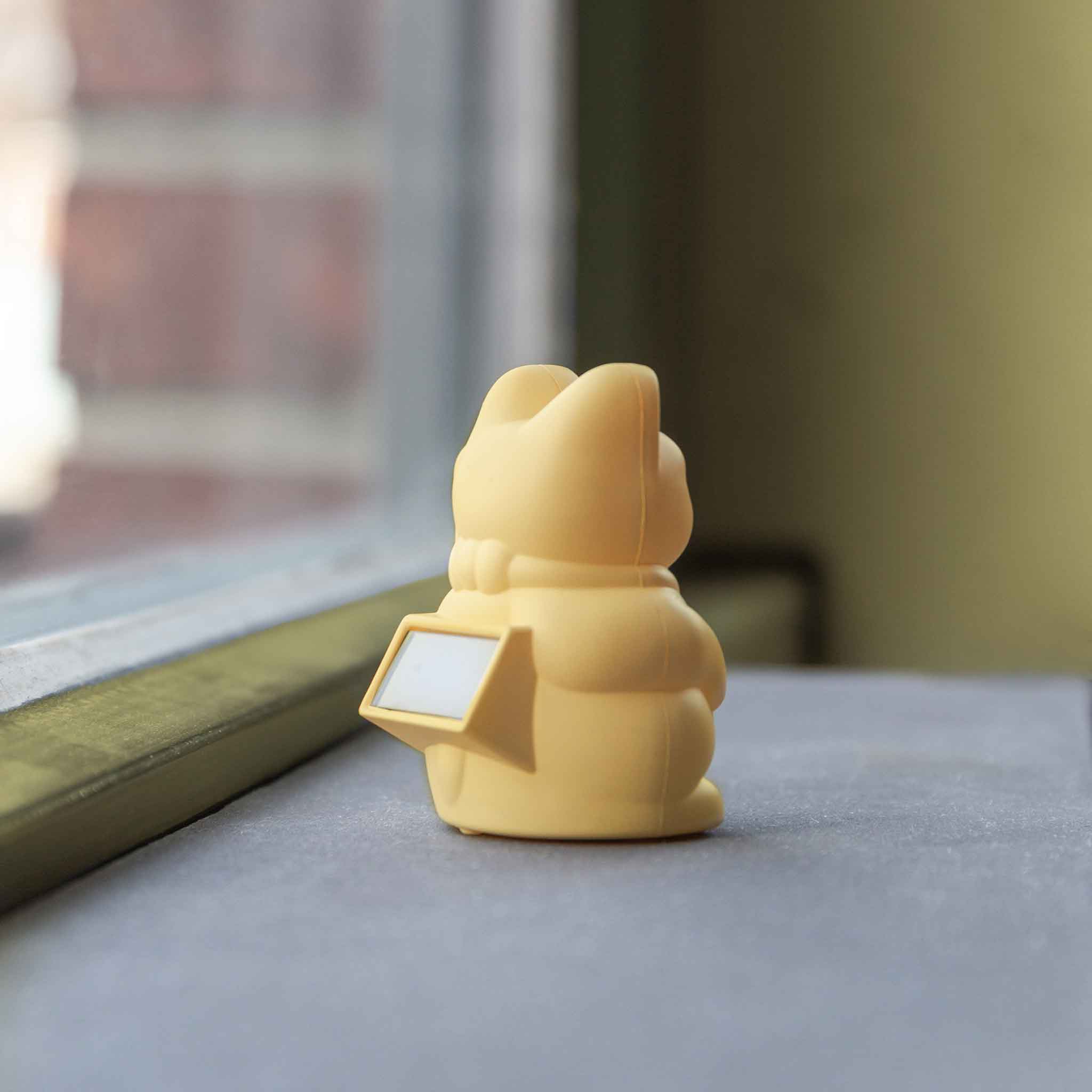 Rückansicht der gelben Solar Winkekatze